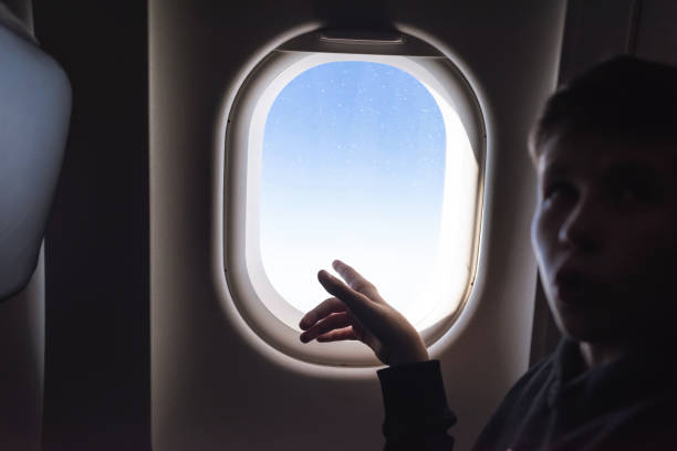 istock A boy have flight looking in the airplane window or porthole. 1138615687