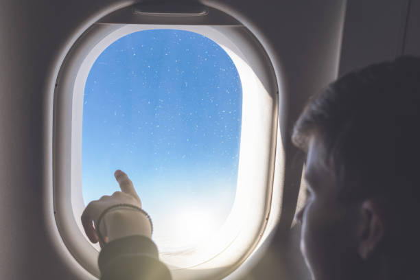 istock A boy have flight looking in the airplane window or porthole. 1138615791