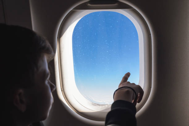 istock A boy have flight looking in the airplane window or porthole. 1138615816