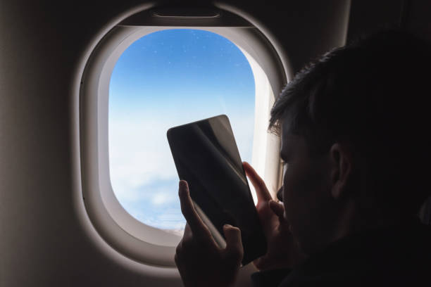 istock Caucasian boy fasten seat belt and using tablet pc and taking picture during air flight.  Safety travel with kid. concept 1138615857