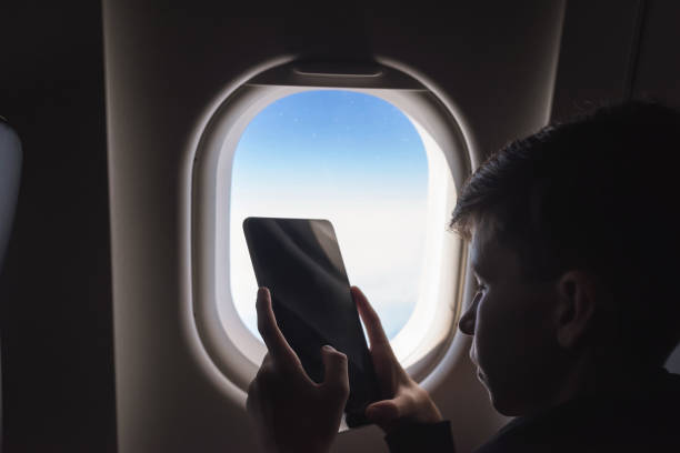 istock Caucasian boy fasten seat belt and using tablet pc and taking picture during air flight.  Safety travel with kid. concept 1138615931