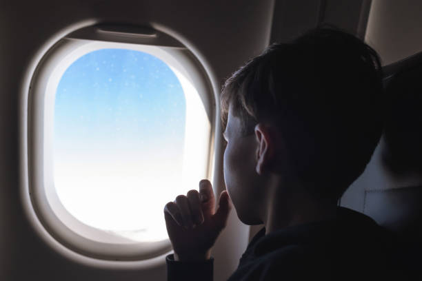 istock A boy have flight looking in the airplane window or porthole. 1138615969