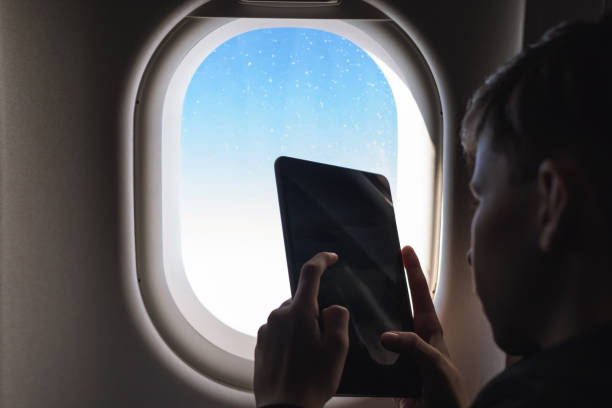 istock Caucasian boy fasten seat belt and using tablet pc and taking picture during air flight.  Safety travel with kid. concept 1138616002