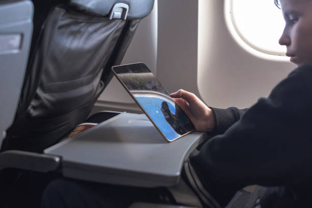 istock Caucasian boy fasten seat belt and using tablet pc during air flight.  Safety travel with kid. concept 1138616043