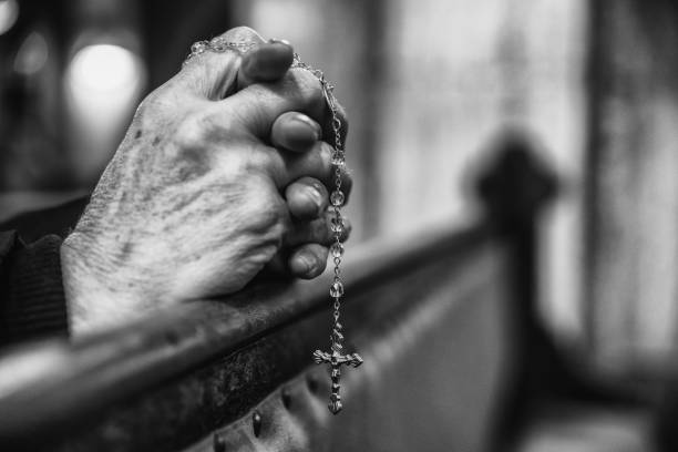 istock Praying hands with rosary in church 1138616877