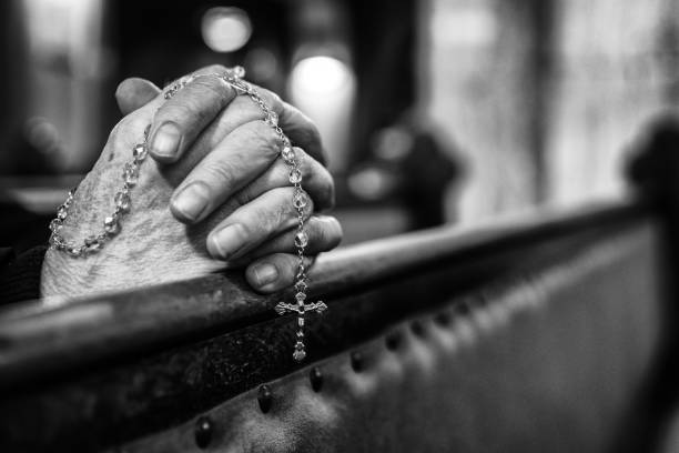 istock Praying hands with rosary in church 1138617061
