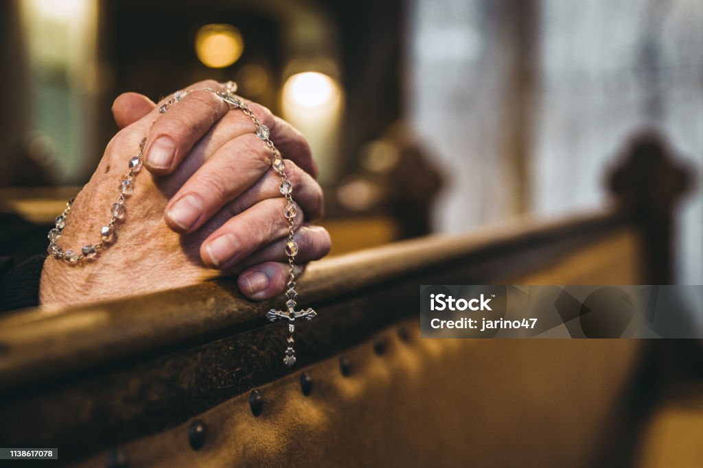 Mãos praying com o Rosário na igreja - Foto de stock de Rezar royalty-free