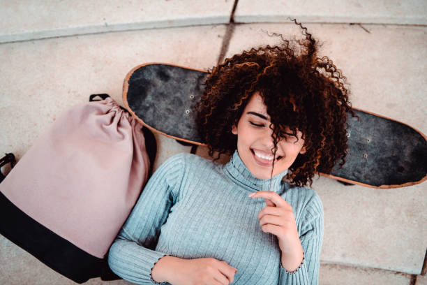 istock Cute Smiling Female Resting Head On Skateboard While Lying Down 1138620802