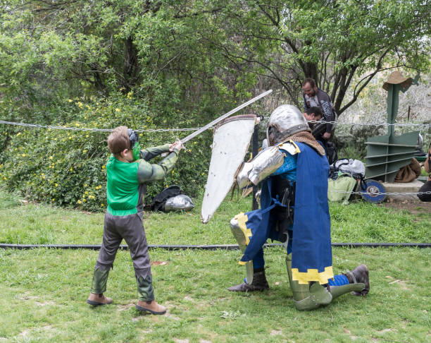 A visitor dressed in a Hulk costume fights with a knight in the ring at the Purim festival with King Arthur in the city of Jerusalem, Israel Jerusalem, Israel, March 23, 2019 : A visitor dressed in a Hulk costume fights with a knight in the ring at the Purim festival with King Arthur in the city of Jerusalem, Israel excalibur stock pictures, royalty-free photos & images