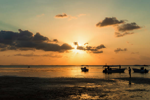 istock Silhouette fishing boat with water reflection on sunset time background, 1138626172