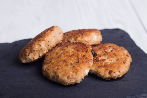 istock cutlets on a black flat plate, on a white wooden background 1138626498