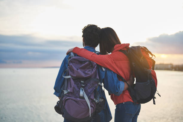 istock Peaceful man and woman watching sunset at seaside 1138627634