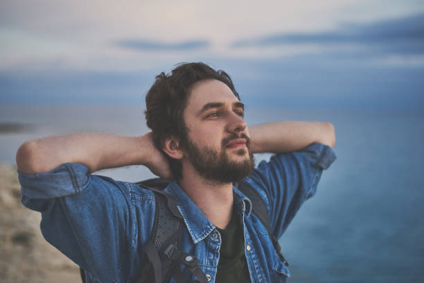 istock Calm young man enjoying sea breeze 1138627684
