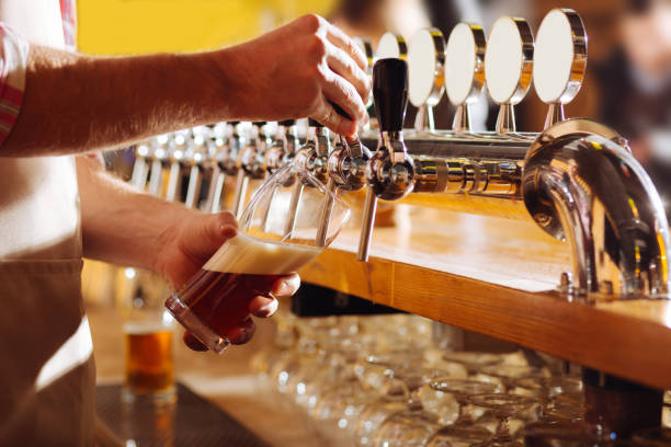 istock Barman wearing beige apron pouring beer for his client 1138629878