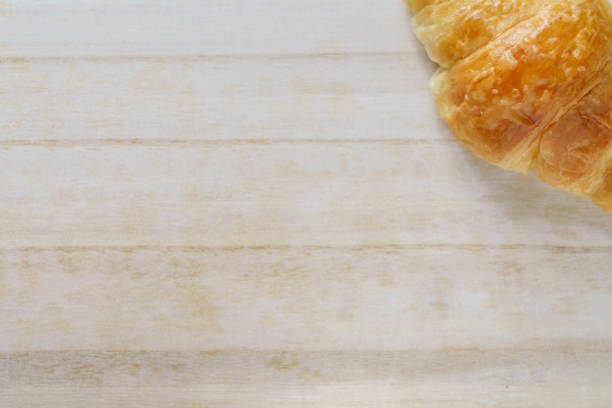 A croissant on a wooden tray
