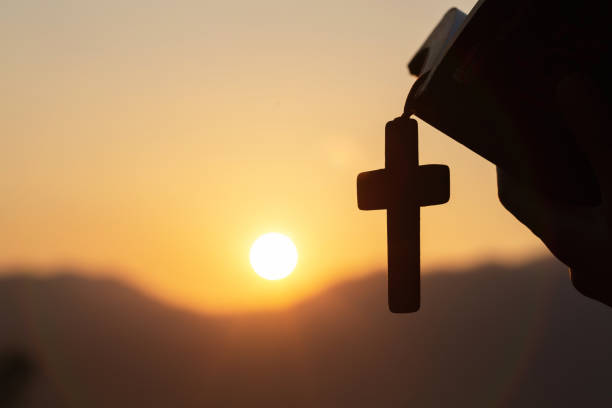 siluette chrześcijańskiej kobiety trzymającej biblię i drewniany naszyjnik krzyża chrześcijańskiego podczas modlitwy do boga. - rosary beads bible prayer beads catholicism zdjęcia i obrazy z banku zdjęć