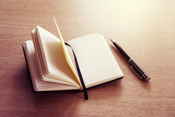 istock Black opened notebook and pen on the table on left top view. 1138633435