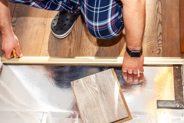 istock Man using measuring tape and pencil while installing new wooden laminate flooring at home. 1138635332