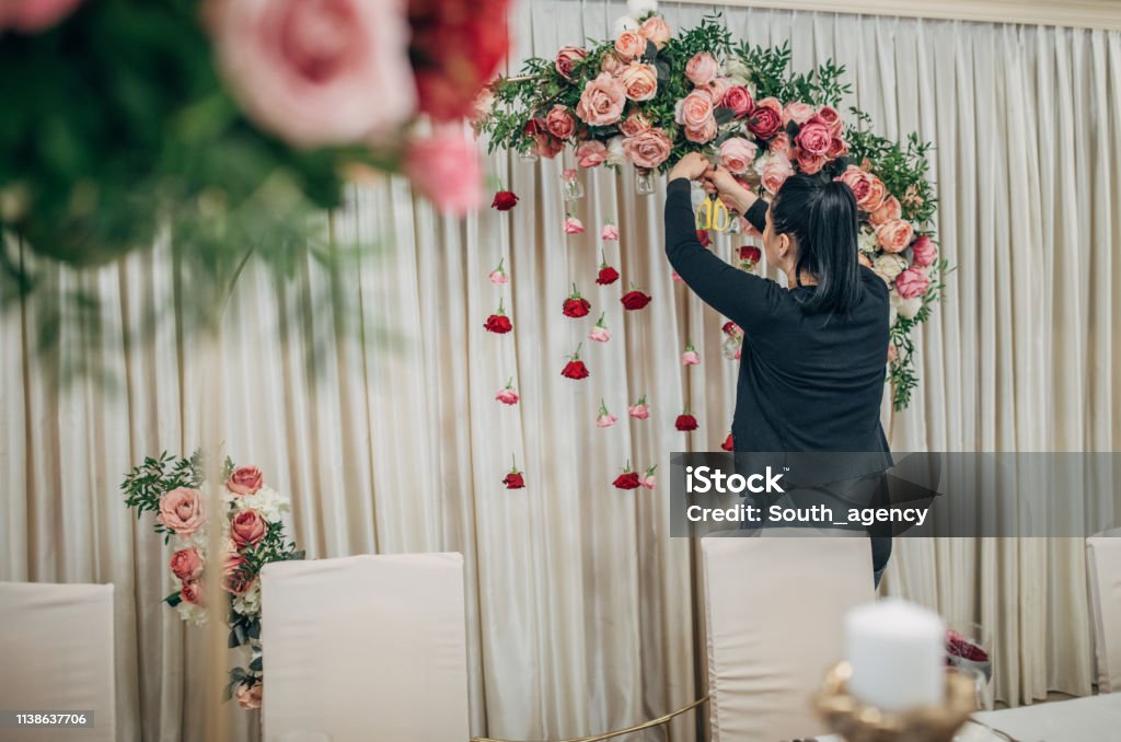 Woman making wedding decoration Woman arranging flower wedding decor Wedding Stock Photo