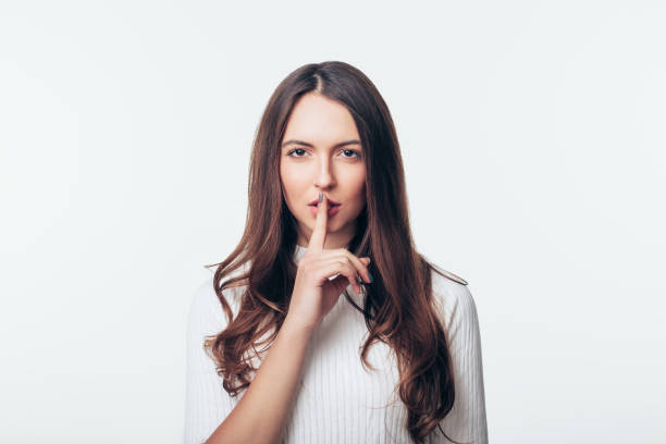 istock Young woman making hush gesture isolated on white background 1138637883
