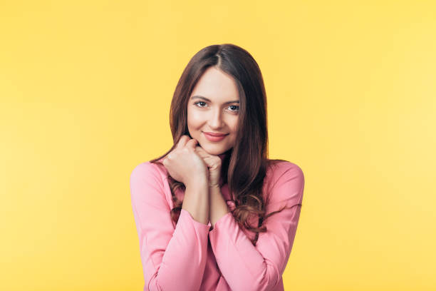 istock Beautiful smiling woman posing over yellow background 1138637903