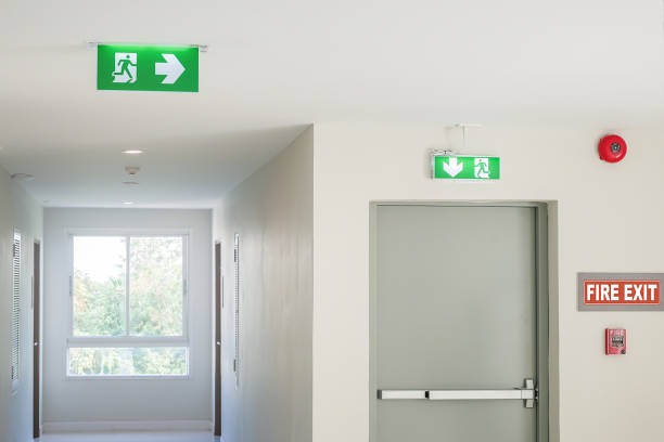 istock Fire exit sign with light on the path way in the hotel or office 1138637972