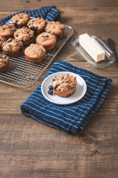 домашние черничные кексы на деревянном столе и голубом кухонном полотенце - muffin blueberry muffin blueberry butter стоковые фото и изображения