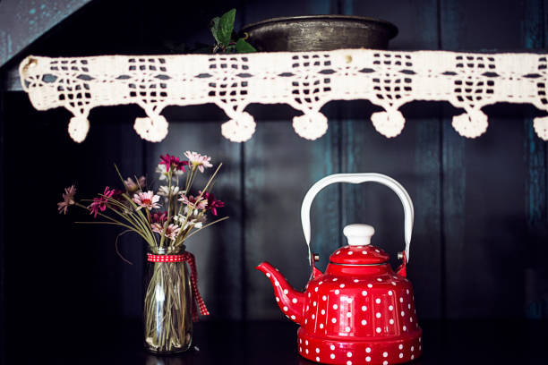 Old metal enamel kettle on wooden shelf