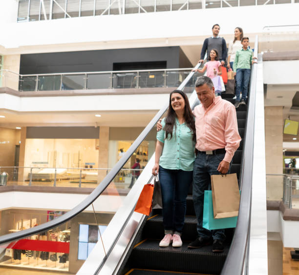 istock Happy shopping people using the escalators at the mall 1138641529