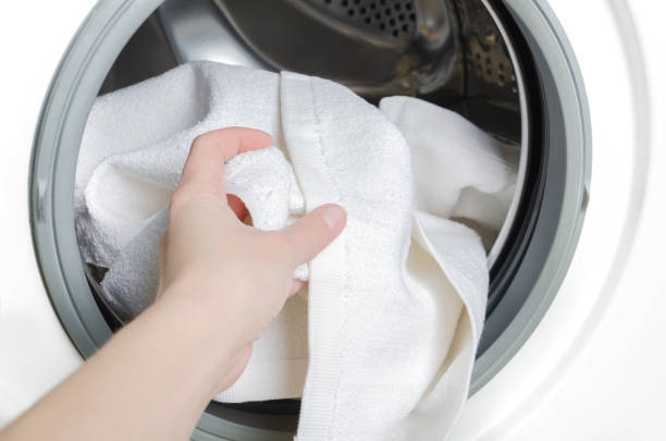 istock Housekeeper taking out clean clothes from washing machine,closeup 1138644083