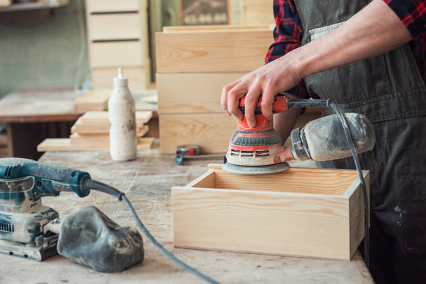 El trabajador muele la caja de madera - foto de stock