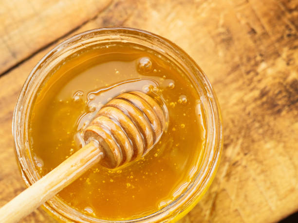 istock honey with wooden mixer top view 1138644780