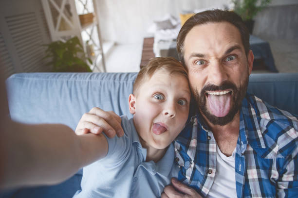 istock Outgoing parent and child grimacing on camera 1138645237
