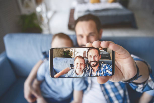 istock Cheerful dad and beaming kid taking selfie 1138645269