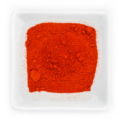 Red smoked paprika powder piment la vera in a white bowl