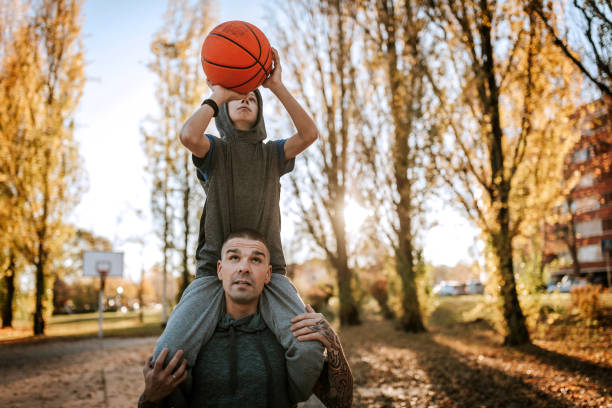 istock Father helping son to make a score in basketball 1138651814