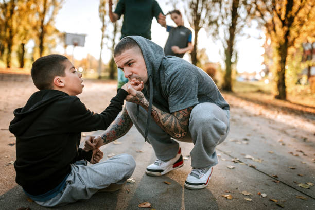 dad kissing son hand after he hurt it - tattoo father family son imagens e fotografias de stock