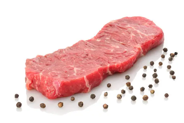 Raw beef rumpsteak with peppercorns white isolated