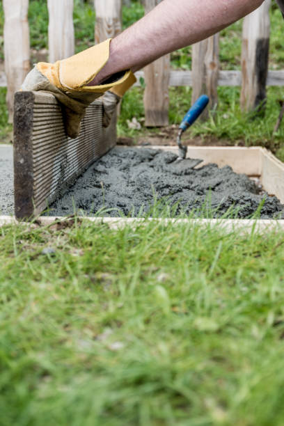 istock Man wearing protective work gloves leveling fresh cement 1138653130