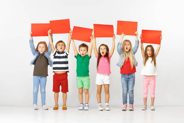 istock Group of children with red banners isolated in white 1138653579