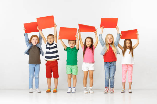 istock Group of children with red banners isolated in white 1138653596