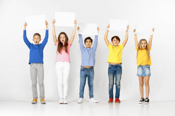 istock Group of children with a white banners isolated in white 1138653699