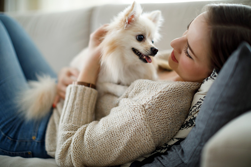 Young woman embracing her dog at home