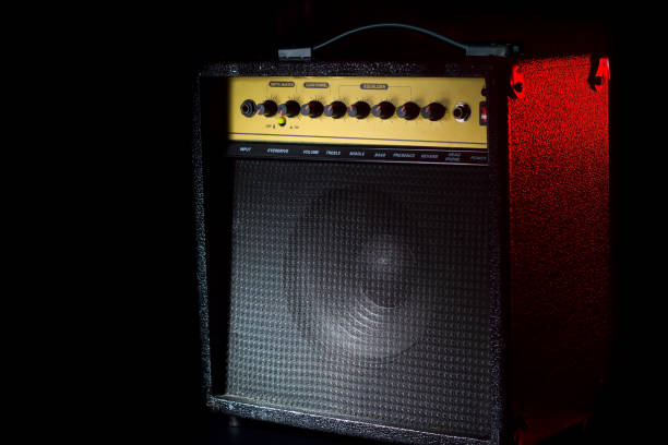 istock Black guitar amplifier on a black background with a red flash. 1138654700