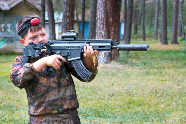 istock Boy playing laser tag outdoors. Military tactical game 1138655718