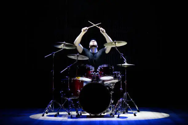 Drummer playing the drums with smoke and powder in the background