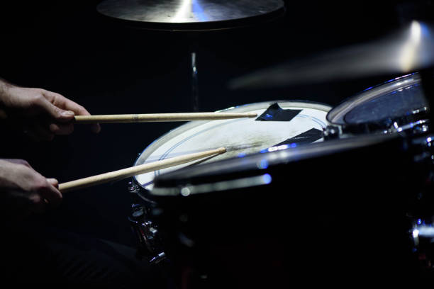 istock man plays musical percussion instrument with sticks closeup on a black background, a musical concept with the working drum, beautiful lighting on the stage 1138667830