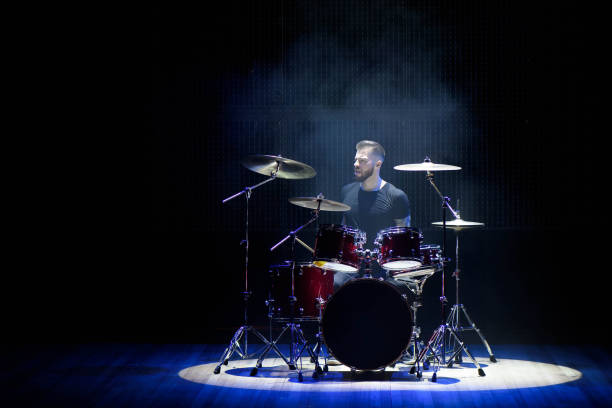 istock Silhouette drummer on stage. Dark background, smoke spotlights 1138667975