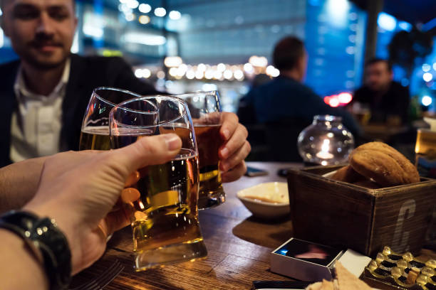 istock Celebratory toast three beer glasses in pub - close-up 1138675085