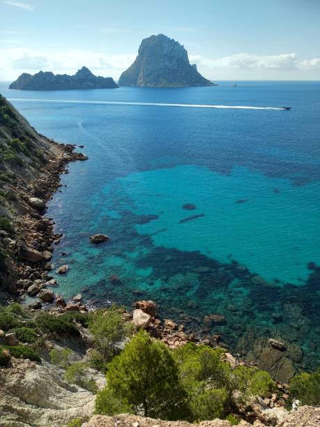 beautiful panorama of the islet of Es Vedra on the cliff of Cala D'Hort in Ibiza, Pitiusa Island of the Balearics beautiful panorama of the islet of Es Vedra on the cliff of Cala D'Hort in Ibiza, Pitiusa Island of the Balearics balearics stock pictures, royalty-free photos & images